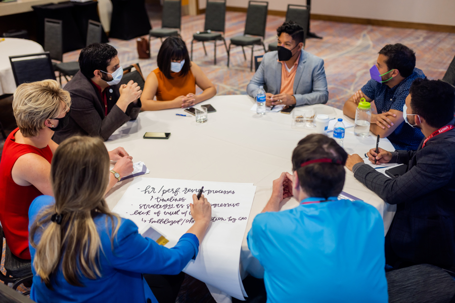 A birds-eye view of a table of LP members strategizing during a breakout session.