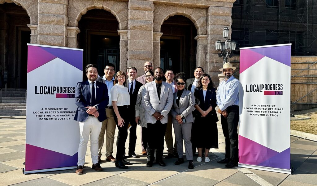 LPTX members and partners posing for a group photo next to two LPTX banners with the state capitol in the background
